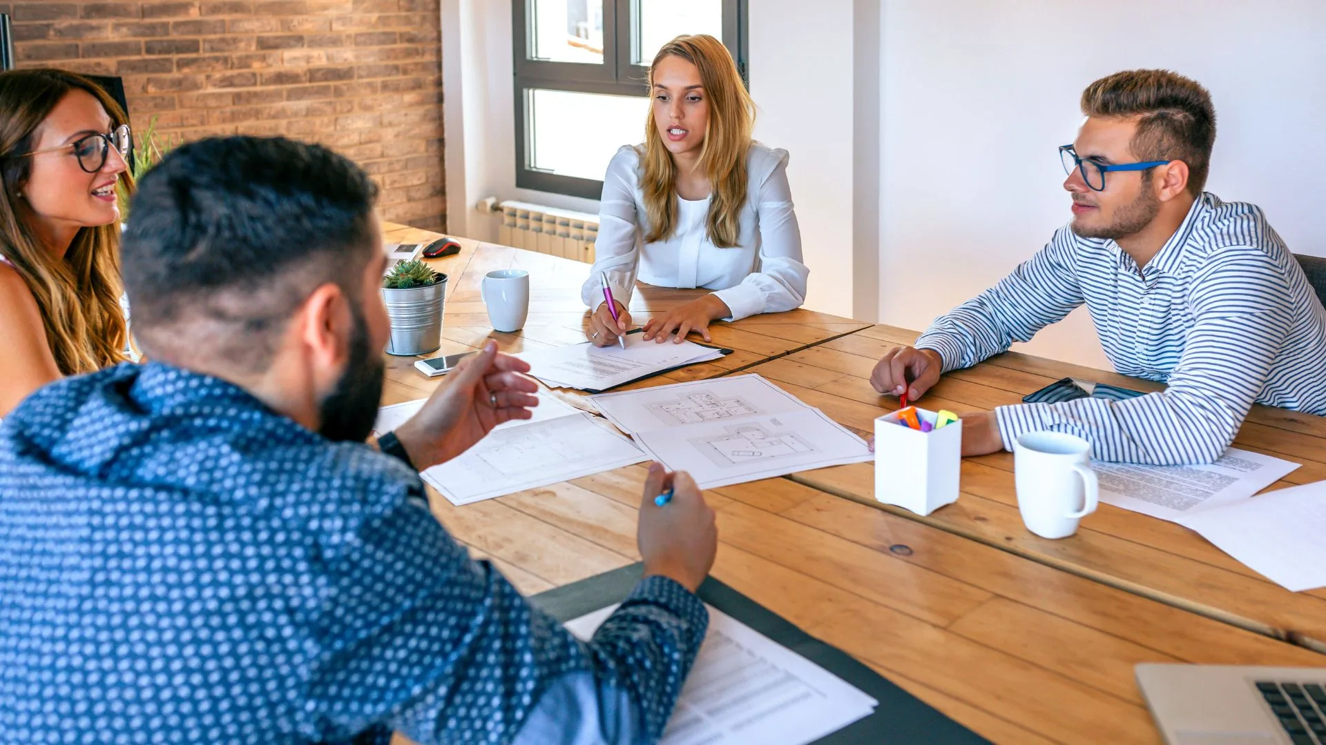 Reference photograph of a project team meeting around plans